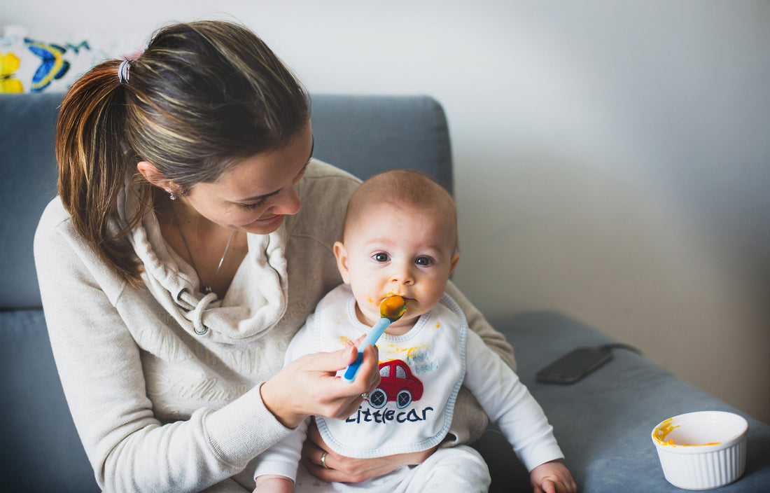 Mom feeding baby on sofa