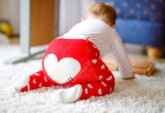 Baby crawling with red pants and heart on tushy