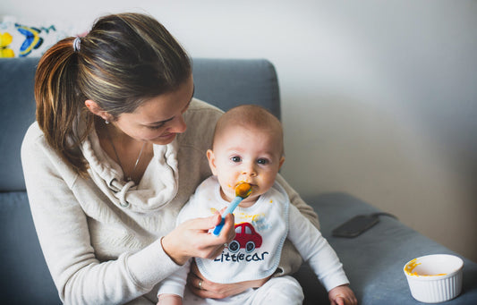 Mom feeding baby on sofa